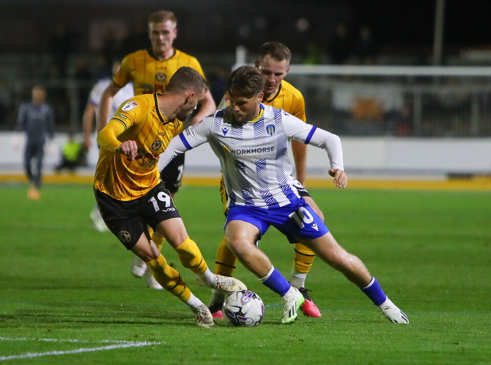 Shane McLoughlin of Newport County vies for the ball with Noah Chilvers of Colchester United