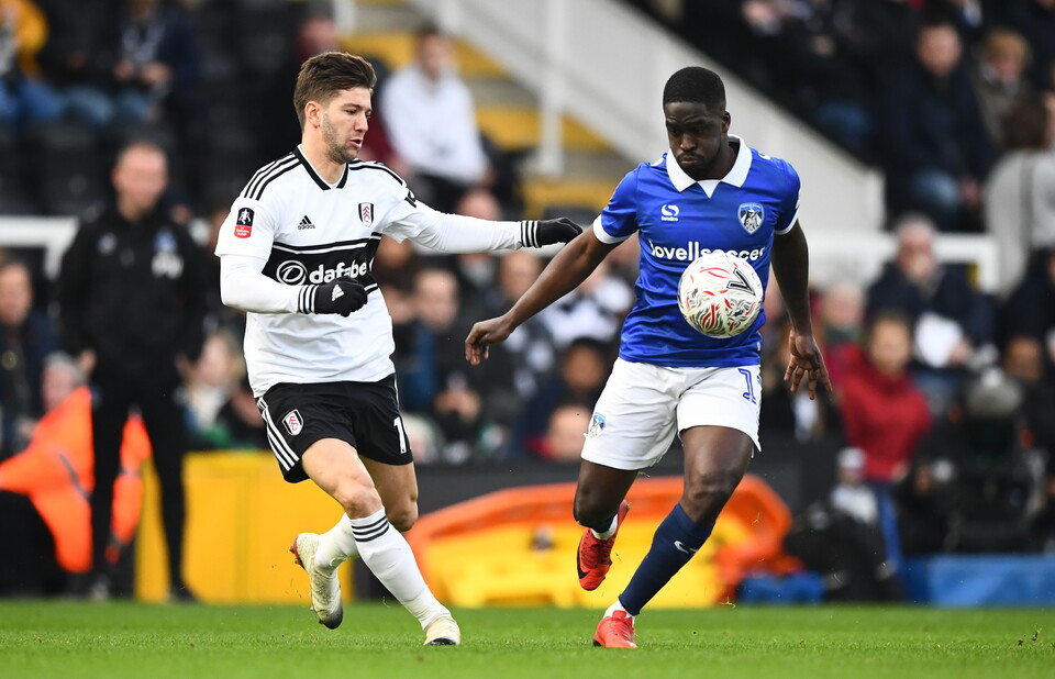 Luciano Vietto of Fulham chases Christopher Missilou of Oldham Athletic